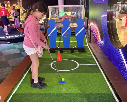 Young girl playing mini golf at Play It, Melbourne.